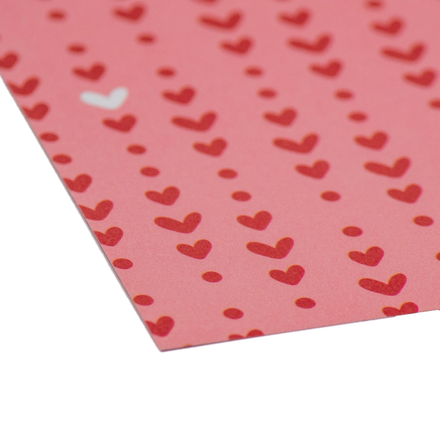 Makroaufnahme: Detailreiche Ansicht der verspielt angeordneten, kleinen roten Herzen auf zartem rosa Hintergrund. Ein inspirierendes Element des Designerpapiers mit roten Herzen von Stanzi.