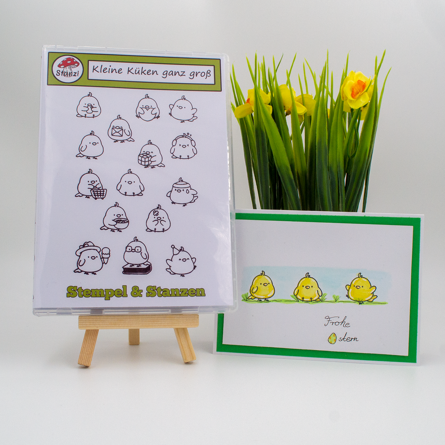 Küken Silikonstempel-Set auf Staffelei, selbstgemachte Karte und gelbe Blumen im Hintergrund