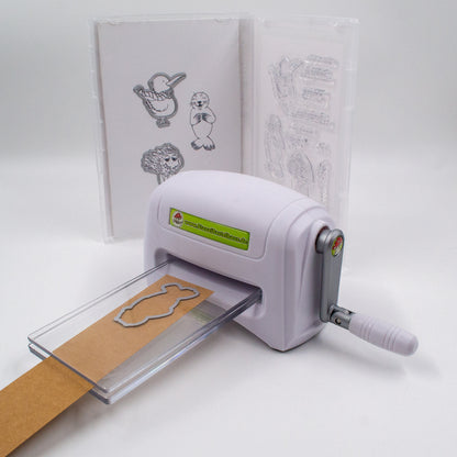 Stanzmaschine im Einsatz mit Stanzi® Stanzschablone – geöffnetes Bastelset im Hintergrund